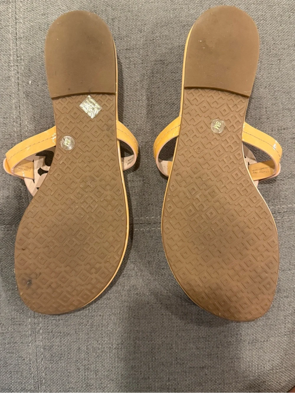 Tory Burch Patent Leather Thong Sandals  color is a pinky peach nude color.